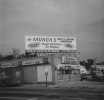 Vintage photograph of the Munch's store with a rooftop sign reading bath and lighting showroom