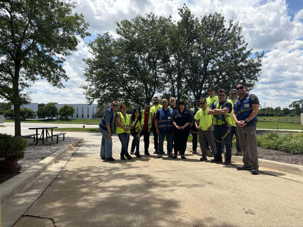 Large branch crew in high visibility vests posed outside on a summer afternoon