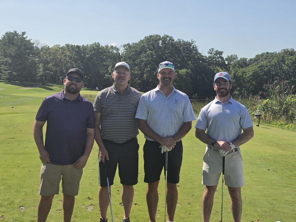 Six golfers with arms around each other on the course