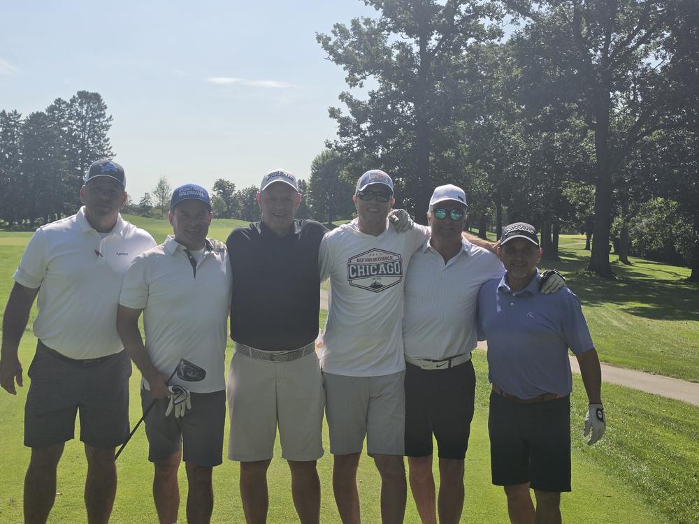 Four golfers with putters standing on the fairway at the Munch's outing