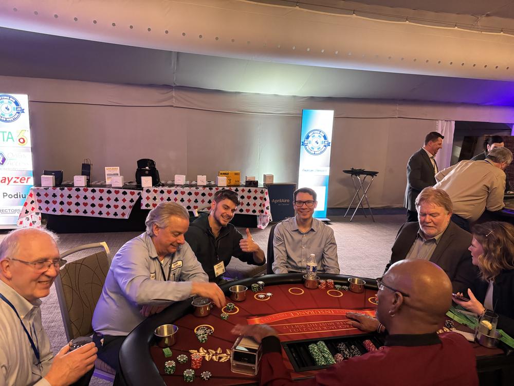 Contractors playing cards at a table during the dealer meeting casino night